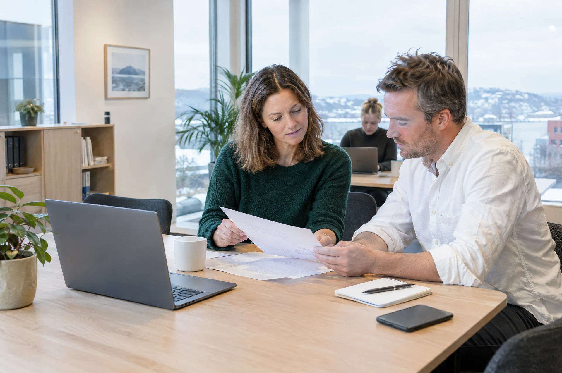 Regnskapsrådgivere i en arbeidssamtale på et lyst kontor